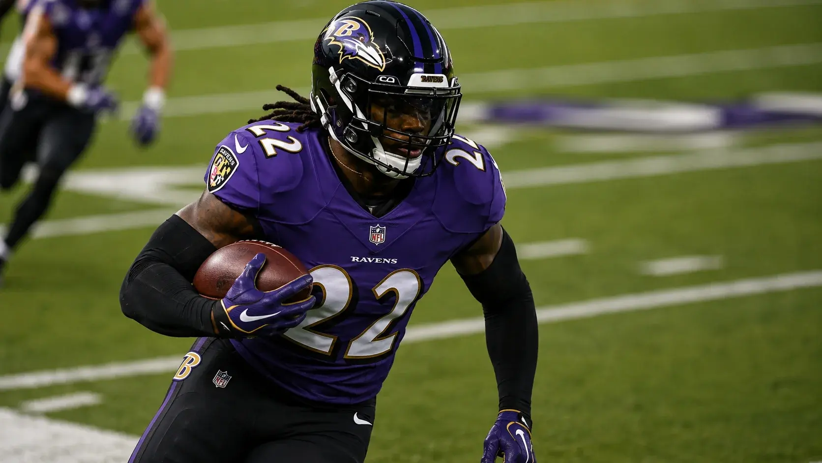 Close-up of an American football player running with the ball during an NFL game